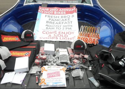 Ballcaps, ice scrapers, dash mats, and pens displayed in a truck bed