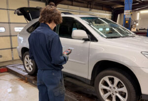 Technician diagnosing vehicle